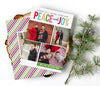 portrait oriented holiday photo card with rainbow text and four photos, colorful striped back side