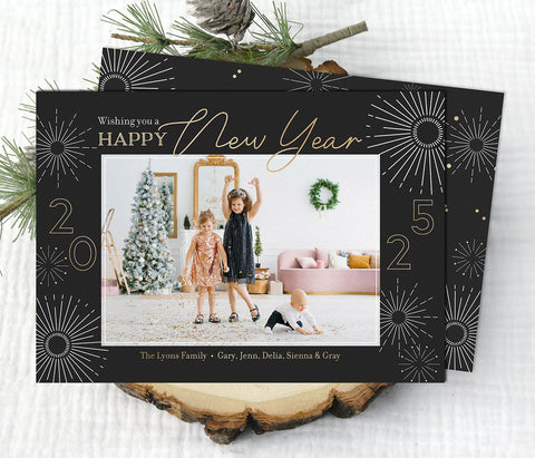 new year holiday photo card in landscape format with a single photo, black background, gold text and white firework graphics