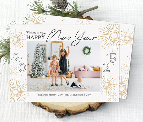 new year holiday photo card in landscape format with a single photo, cream background, black text and gold firework graphics