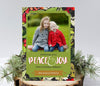 christmas or holiday photo card in portrait orientation featuring a painted red and green holly on black background, gold frame and a single photo