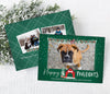 dog themed holiday card with single photo against a green background. traditional red and green christmas garland along the top and a dog house and christmas tree at the bottom. happy pawlidays wording