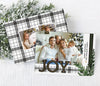 holiday card in horizontal orientation with a single photo, black and green ribbon, plaid ribbon, large JOY text and evergreen branch detail