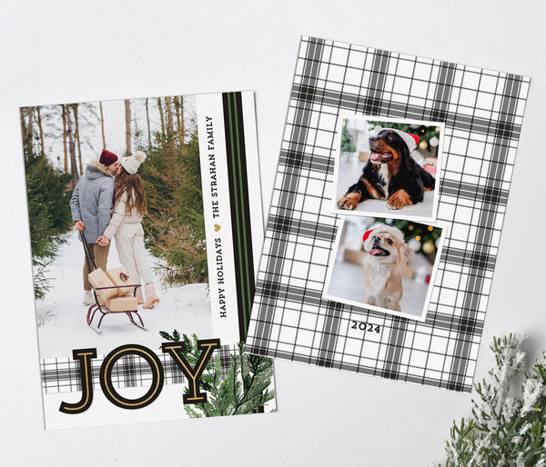 holiday card in portrait orientation with a single photo, black and green ribbon, plaid ribbon, large JOY text and evergreen branch detail