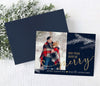 christmas photo card with navy blue background, a single photo, gold text and white pine branches, back side is striped gold pattern