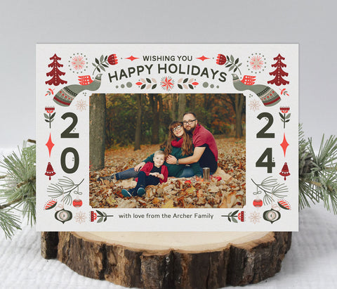 christmas photo card with a white background, a single photo framed with red and green nordic themed holiday graphics