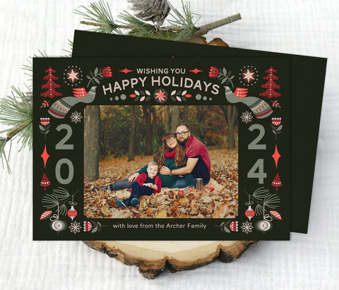 christmas photo card with a dark green background, a single photo framed with red and green nordic themed holiday graphics