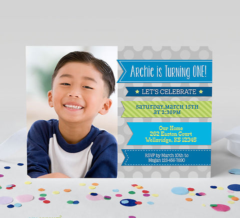 boy birthday invitation with single photo on left, blue and green ribbons on right with party details and a gray polka dot background