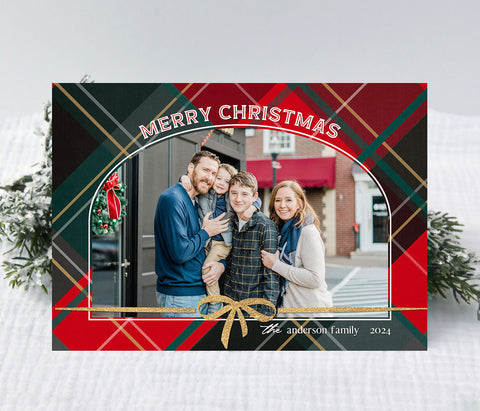 horizontal christmas card with red and green plaid background and a single arched photo