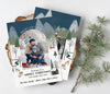 vertical christmas or holiday card with a single arched photos and winter woodland themed graphics with a blue sky, back side features the same pattern and an additional photo